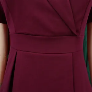 Close-up detail of a burgundy short-sleeved elegant dress showing waist and fabric texture