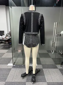 Vista posteriore di un elegante set nero con strass, giacca corta e pantaloncini abbinati.