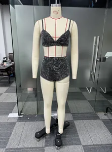 Dettaglio di un completo due pezzi nero sexy con strass argentati luccicanti su manichino