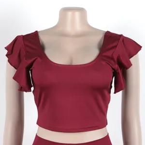 Detail van een bordeauxrode crop top met ruchesmouwen uit een tweedelige set voor dames