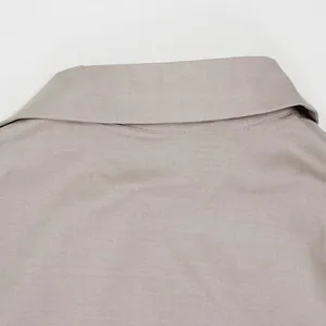 Detailansicht des feinen Twill-Stoffes und des Kragens eines khakifarbenen Hemdes.