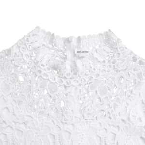 Detailed macro view of white lace floral neckline with brand tag on hollow jumpsuit