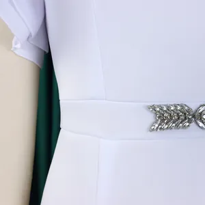 Detail of white evening dress with ruffled sleeves and rhinestone leaf waist belt.