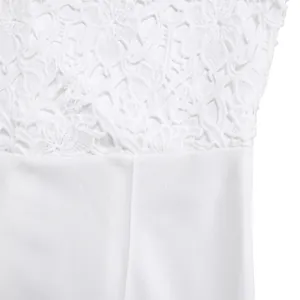Detailed macro view showing the intricate floral lace texture on a white fashion jumpsuit