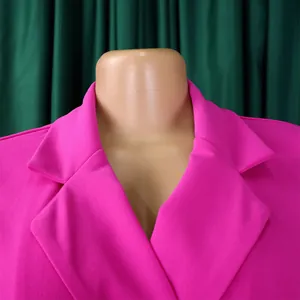 Gros plan du col de blazer fuchsia sur une robe grande taille en tissu texturé