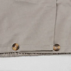 Makrodetail der Hornknöpfe und der Twill-Stofftextur an einem khakifarbenen Anzug