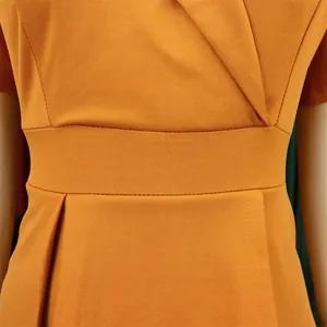 Close-up of mustard yellow African dress with textured fabric and V-neck detail