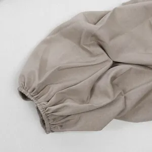 Detailaufnahme der plissierten elastischen Manschette am khakifarbenen Ärmel