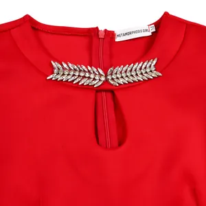 Detail of red party dress with rhinestone embellished round neckline and keyhole