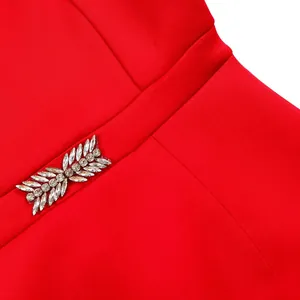 Close-up detail of silver rhinestone leaf embellishment on vibrant red dress waist
