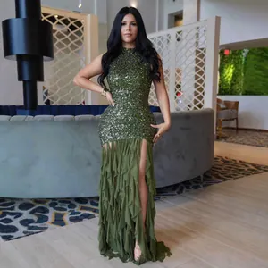 Close-up detail of an elegant olive green sequined mesh dress with ruffled high slit