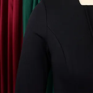 Detailed close-up showing the shoulder seam and neckline of a black long-sleeve dress