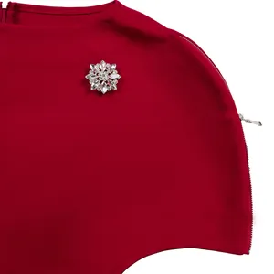 Primo piano di un elegante abito rosso decorato con una scintillante spilla floreale in strass