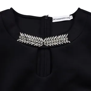 Macro view of sparkling rhinestone leaf decoration on black round neck hollow party dress