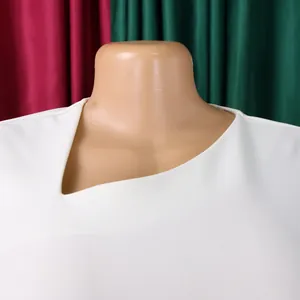 Detailed close-up of an elegant white dress featuring a unique asymmetrical neckline design
