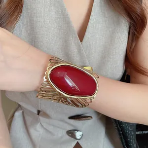 Close-up detail of a vintage hollow metal cuff bracelet with a large red oval stone