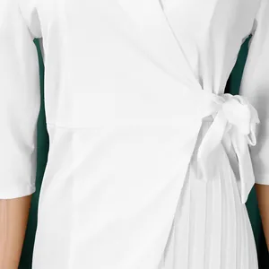Détail d'une robe portefeuille blanche grande taille avec nœud latéral et plissage