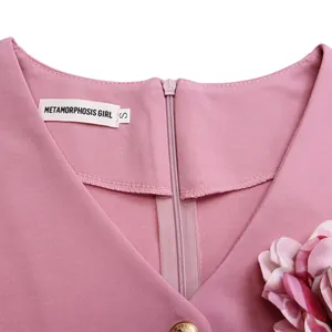 Primo piano della scollatura di un vestito rosa con cerniera nascosta e dettaglio etichetta