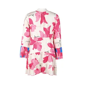 Back view of a white mini dress featuring pink floral prints and blue ruffled cuffs.