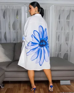 Achteraanzicht van elegant wit shirt met grote blauwe bloemenprint en asymmetrische zoom