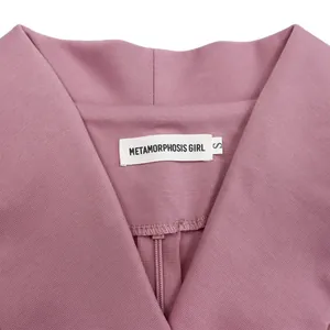 Close-up detail of a pink African dress collar showing the Metamorphosis Girl brand label