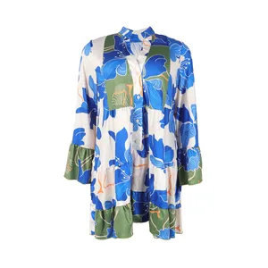 Detailed view of the vibrant blue floral print and ruffled cuffs on this loose V-neck dress