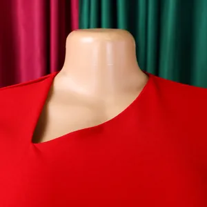 Close-up detail of an elegant red dress featuring a unique diagonal asymmetric neckline