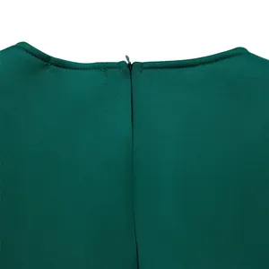 Detailed close-up showing the invisible zipper and neckline of a dark green party dress