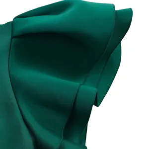 Close-up detail of dark green dress showing elegant double-layered ruffle sleeve design