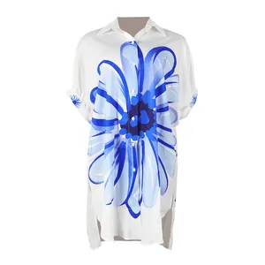 Elegante lange witte blouse met levendige blauwe bloemenprint en asymmetrische zoom