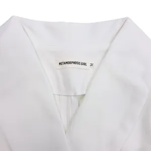 Detailed view of the V-neckline and brand label on this elegant white dress for women