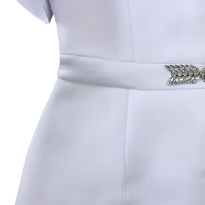 Detail of white party dress waist with elegant rhinestone leaf buckle decoration.