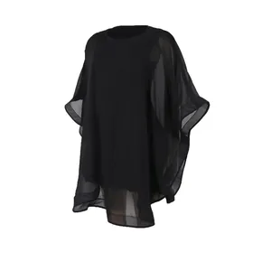 Primer plano de la tela de gasa negra transparente en un vestido tipo poncho holgado