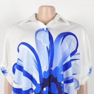 Gedetailleerd overzicht van elegant wit overhemd met blauwe bloemenprint en revers