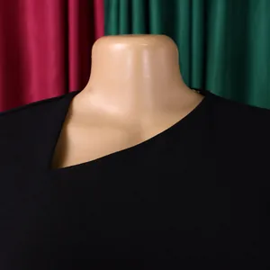 Close-up detail of an asymmetrical slant neckline on this elegant black midi dress