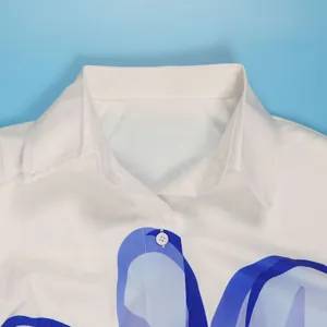 Detailopname van een witte hemdkraag met een elegant en stijlvol blauw bloemenpatroon