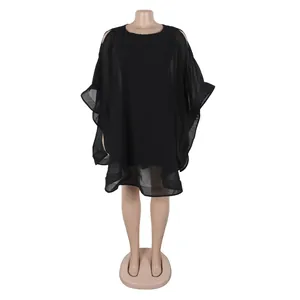Detalle de un vestido poncho de gasa negra con silueta holgada sobre un maniquí.