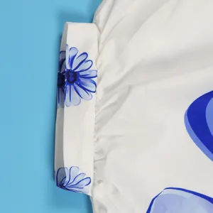 Detailopname van elegant blauw bloemenprintpatroon op een wit stoffen shirt voor dames