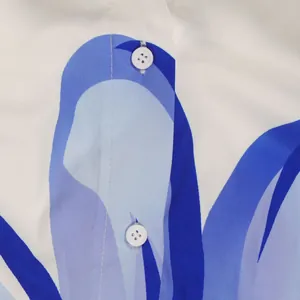 Macroweergave van witte knopen en blauwe bloemenprint op hoogwaardig shirt