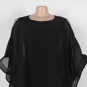 Primer plano detallado del escote y las mangas del elegante vestido capa de gasa negra