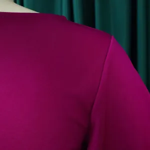 Close-up of the vibrant magenta fabric texture on a high-waist ruffle sleeve dress detail