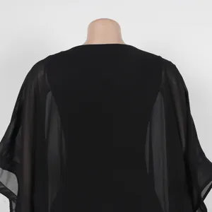 Vista trasera con mangas de gasa transparente de este elegante vestido de capa negro suelto