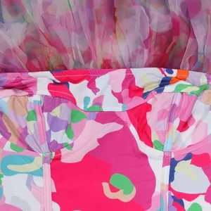 Zoom sur l'imprimé abstrait coloré et le détail en tulle transparent de cette robe.