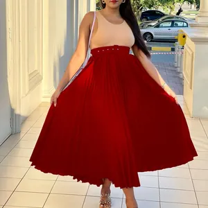 Élégante jupe midi plissée rouge à taille haute avec ceinture montrant le drapé du tissu.