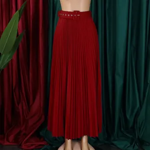 Détail d'une jupe plissée rouge à taille haute avec ceinture à boucle carrée assortie