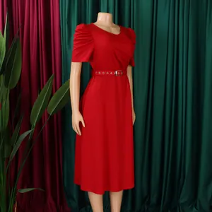 Close-up of elegant red V-neck dress with puff sleeves and matching belt on mannequin.