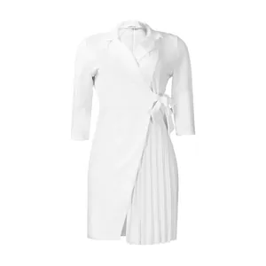Détail d'une robe portefeuille blanche à col tailleur et jupe plissée élégante.