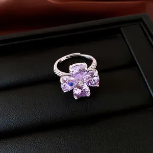 Gedetailleerde weergave van een zilveren ring met vier paarse hartvormige zirkonia-klaver.