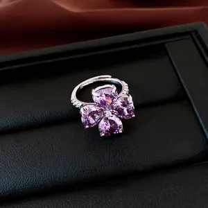 Close-up van een klavertjevier ring met paarse hartvormige zirkonia stenen in detail view.
