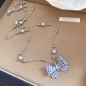 Elegante collana di perle con ciondolo a fiocco a pois bianchi e neri in acrilico da donna.